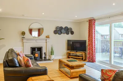 a living room with a couch and a tv at Peregrine Cottage with Hot Tub in Newton Stewart