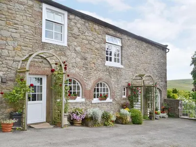 a brick house with two arches and flowers on it at Rose Cottage - Lpd in Ireby