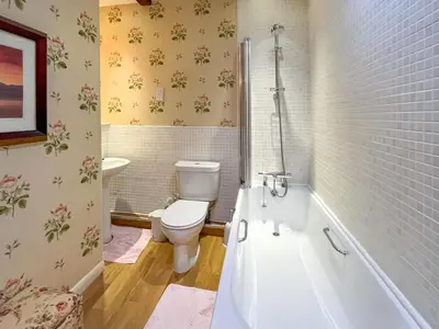 a bathroom with a toilet and a tub and a sink at Rose Cottage - Lpd in Ireby