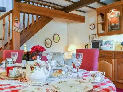 a dining room table with a table cloth with a tea set at Rosedale- Lyl in Ireby
