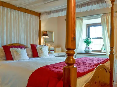 a bedroom with a canopy bed with a red blanket at Rosedale- Lyl in Ireby