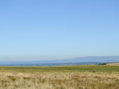 a field of grass with mountains in the background at Swaledale Cottag in Caldbeck