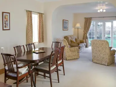 a living room with a dining room table and chairs at Alby Bungalow in Wetheral