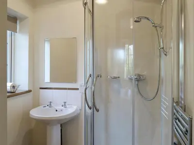 a white bathroom with a sink and a shower at Alby Bungalow in Wetheral
