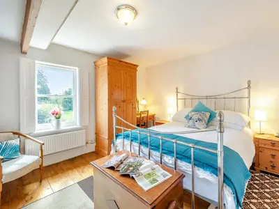 a bedroom with a bed and a chair and a window at Hollow Creek Cottage - 28012 in Rockcliffe