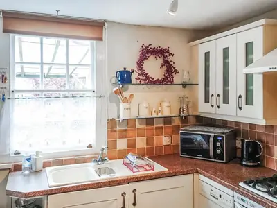 a kitchen with a sink and a microwave at Tanner's Cottage in Cockermouth