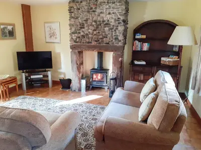 a living room with a couch and a fireplace at Beck Cottage in Ennerdale Bridge