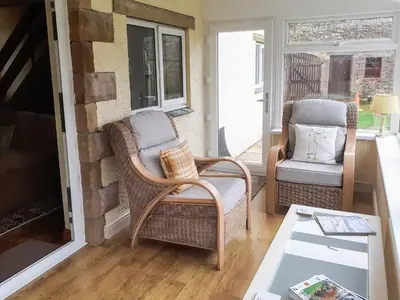 a living room with two chairs and a fireplace at Beck Cottage in Ennerdale Bridge