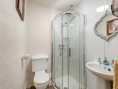 a bathroom with a shower and a toilet and a sink at Halls Bank Farm in Plumbland