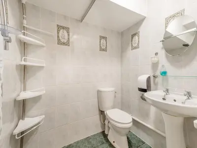 a white bathroom with a toilet and a sink at Berwyn Bank in Gilcrux