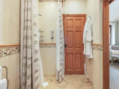 a bathroom with a shower and a wooden door at Beckside in Gilcrux