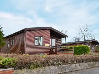 a small wooden house with a brown at Rosella in Bridekirk