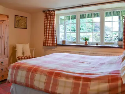 a bedroom with a bed and a window at Birkerthwaite Cottage-W41479 in Eskdale
