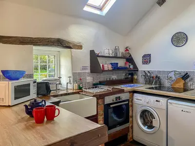 a kitchen with a sink and a washing machine at Birkerthwaire Stable-W41477 in Eskdale