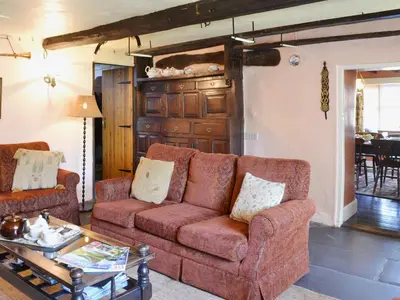 a living room with a couch and a table at Birkerthwaite Farmhouse in Eskdale