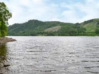 a large body of water with mountains in the background at The Coach House in Thirlmere