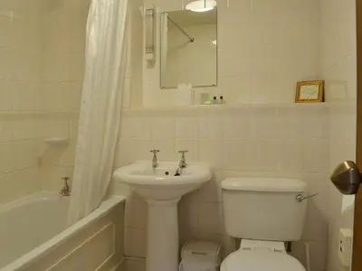 a bathroom with a sink and a toilet and a bath tub at Grooms Room in Thirlmere