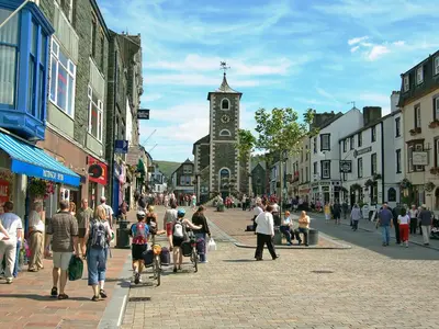 a crowd of people walking down a street with a clock tower at Grooms Room in Thirlmere