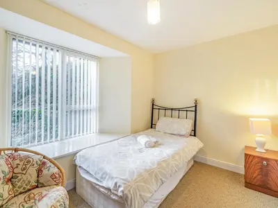 a bedroom with a bed and a chair and a window at Galena in Glenridding