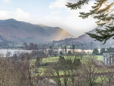 a view of a lake and mountains with a rainbow at Galena in Glenridding