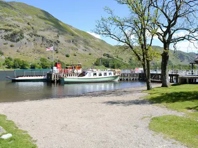 two boats are docked at a dock on the water at Stybarrow View Cottage in Glenridding