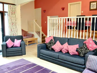 a living room with a blue couch with pink pillows at Bank End in Glenridding