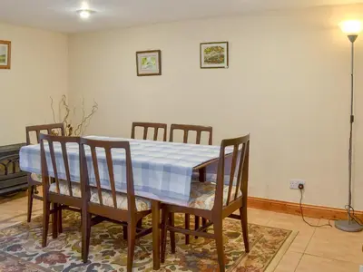 a dining room table with chairs and a blue and white table cloth at Stonefold Cottage in Waberthwaite