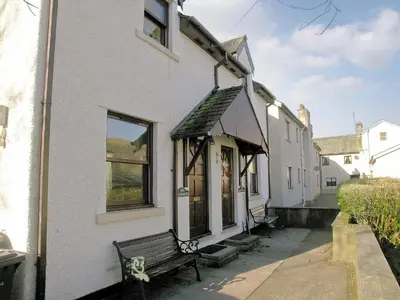 a white building with a bench in front of it at Inglewood - 15288 in Keswick