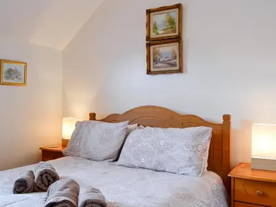 a bedroom with a bed with slippers on it at Inglewood - 15288 in Keswick