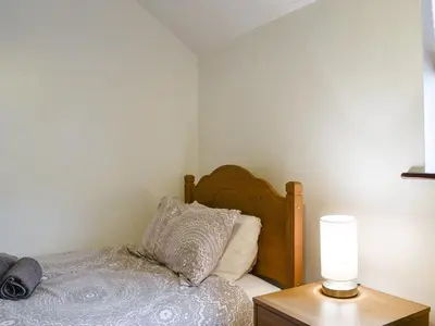 a bedroom with a bed and a table with a lamp at Glenwood - 18630 in Keswick