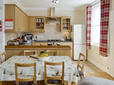 a kitchen with a table with chairs and a refrigerator at Skiddaw View in Keswick