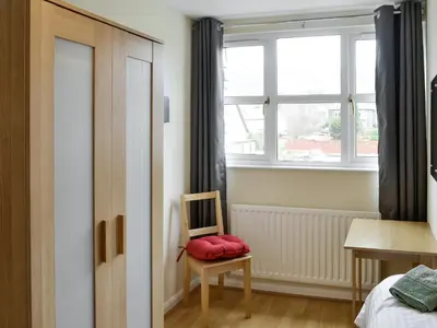 a bedroom with a chair and a window at Skiddaw View in Keswick