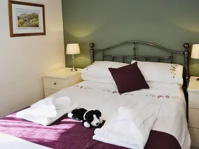 a black and white dog laying on a bed at Bram Crag Barn in Legburthwaite