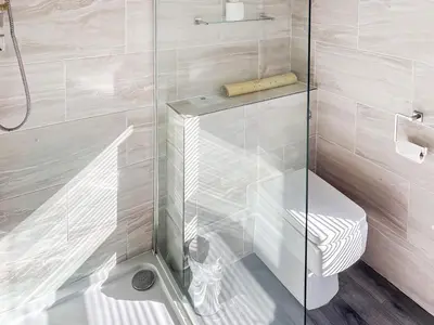 a bathroom with a glass shower with a toilet at Leatheswater in Thirlmere
