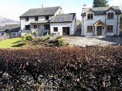 a large white house with a yard with bushes at Jebel Kasr in Braithwaite
