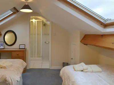 a attic bedroom with two beds and a shower at Quiet Ways in Portinscale
