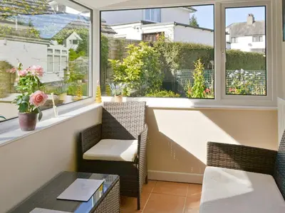a balcony with two chairs and a table and windows at Quiet Ways in Portinscale