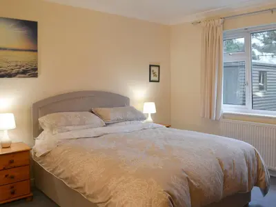 a bedroom with a bed with two lamps and a window at Quiet Ways in Portinscale