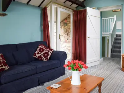 a living room with a blue couch and a table with flowers at Lowther - Np2801 in Dockray