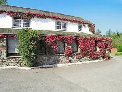a building with red flowers on the side of it at Little Beck in Troutbeck