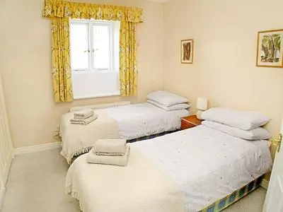 a room with three beds and a window at Aira Cottage in Watermillock