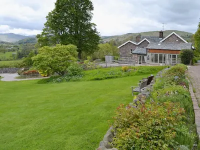 a house with a green lawn in front of it at The Carriage House in Watermillock