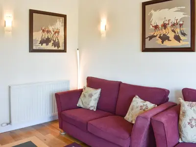 a purple couch in a living room with two pictures at The Carriage House in Watermillock