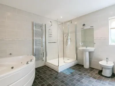 a bathroom with a tub and a toilet and a sink at Oaklands in Langrigg