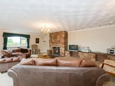 a living room with two couches and a fireplace at Oaklands in Langrigg
