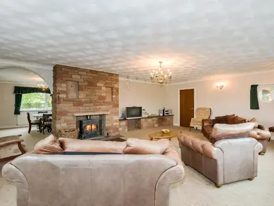 a living room with two couches and a fireplace at Oaklands in Langrigg