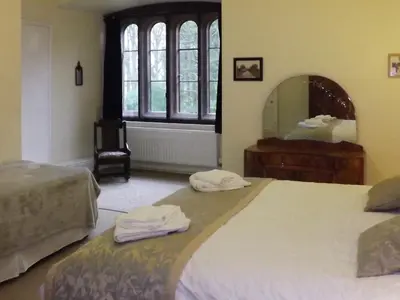 a bedroom with two beds and a large mirror at Whitehall Pele Tower in Mealsgate