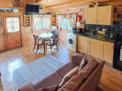 a living room with a couch and a table in a cabin at Hedgehog Meadows in Waverton