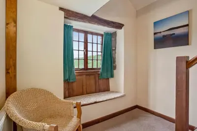 a small room with a chair and a window at The Coppermines Mountain Cottages - Carpenters, Millrace, Pelton Wheel, Sleeps 14 in Coniston