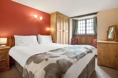 a bedroom with a large bed in a room at The Coppermines Mountain Cottages - Sawyers, Carpenters, Millrace, Sleeps 18 in Coniston